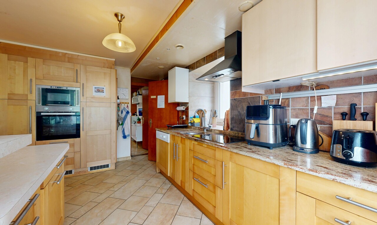 cuisine avec four, hotte, plaque de cuisson, micro-ondes, et backsplash