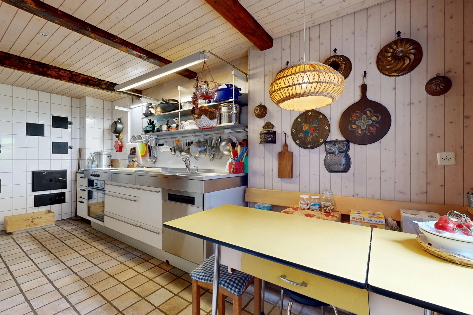kitchen featuring wood walls, black oven, dishwasher, and a wooden ceiling with exposed beams