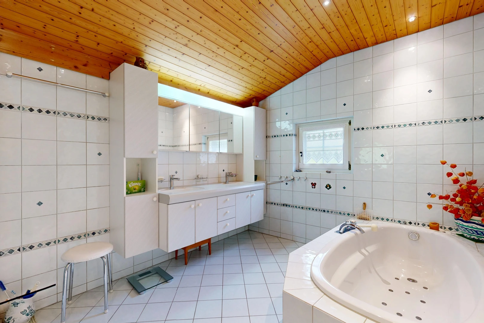 full bathroom with tile walls, a vaulted wood ceiling, a bath, double vanity, and light tile patterned floors