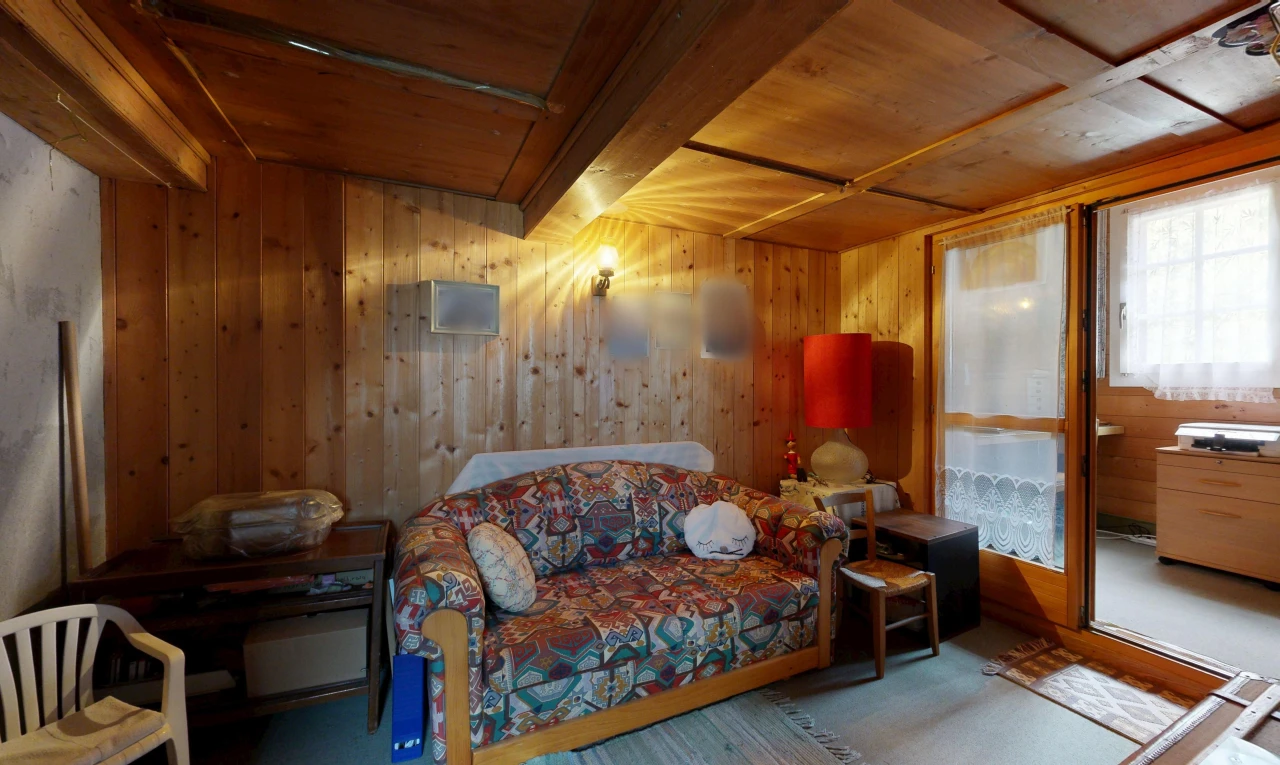 living area with wooden walls and a wooden ceiling with exposed beams