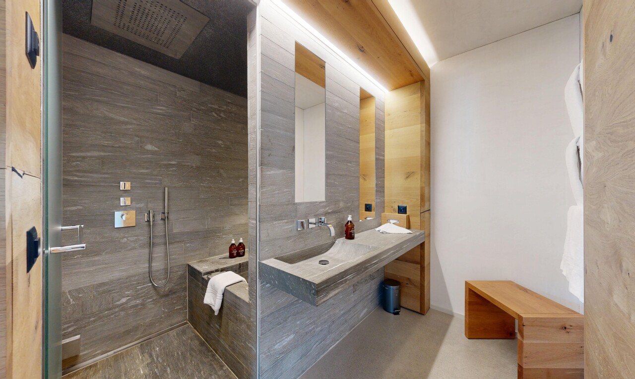bathroom featuring finished concrete floors, walk in shower, and vanity