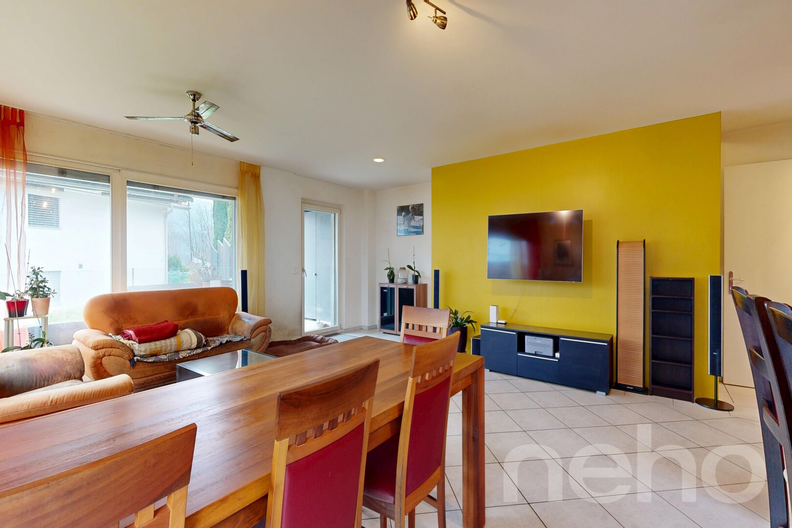 wohn- / esszimmer mit fernseher, gipskartonwand, drywall, deckenventilator, und inside property