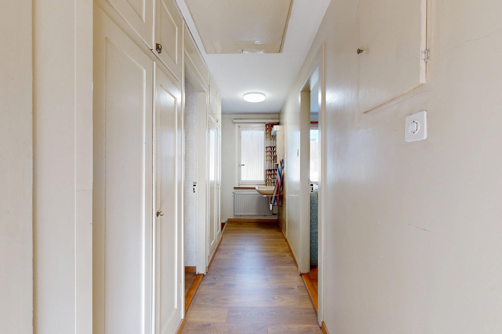 couloir avec inside property, wood finish floor, sol en finition bois, drywall, et cloison sèche