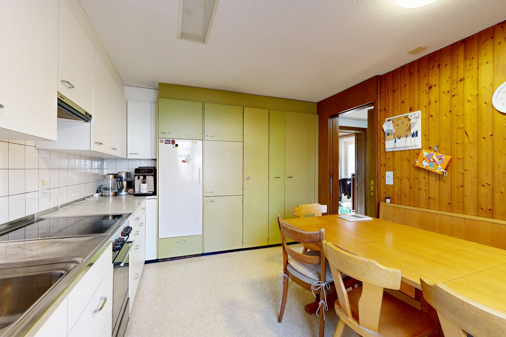 cuisine avec inside property, wood wall, mur en bois, four, et réfrigérateur