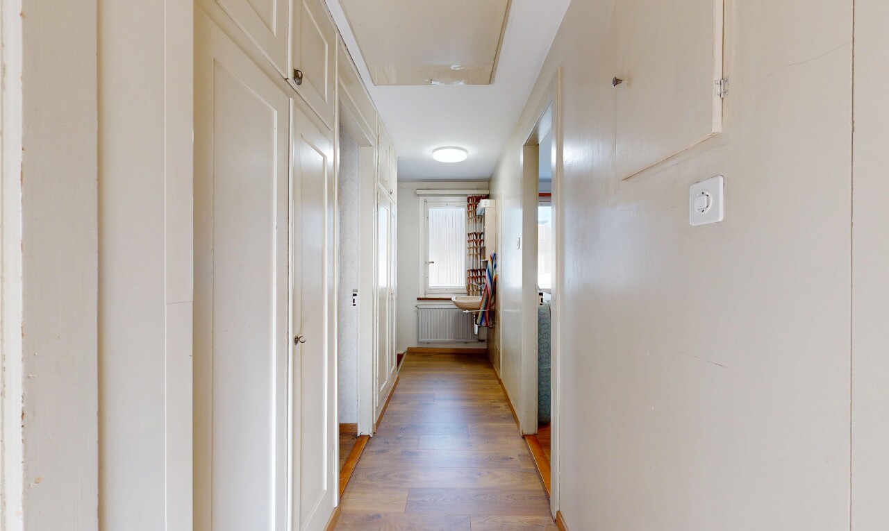 couloir avec inside property, wood finish floor, sol en finition bois, drywall, et cloison sèche