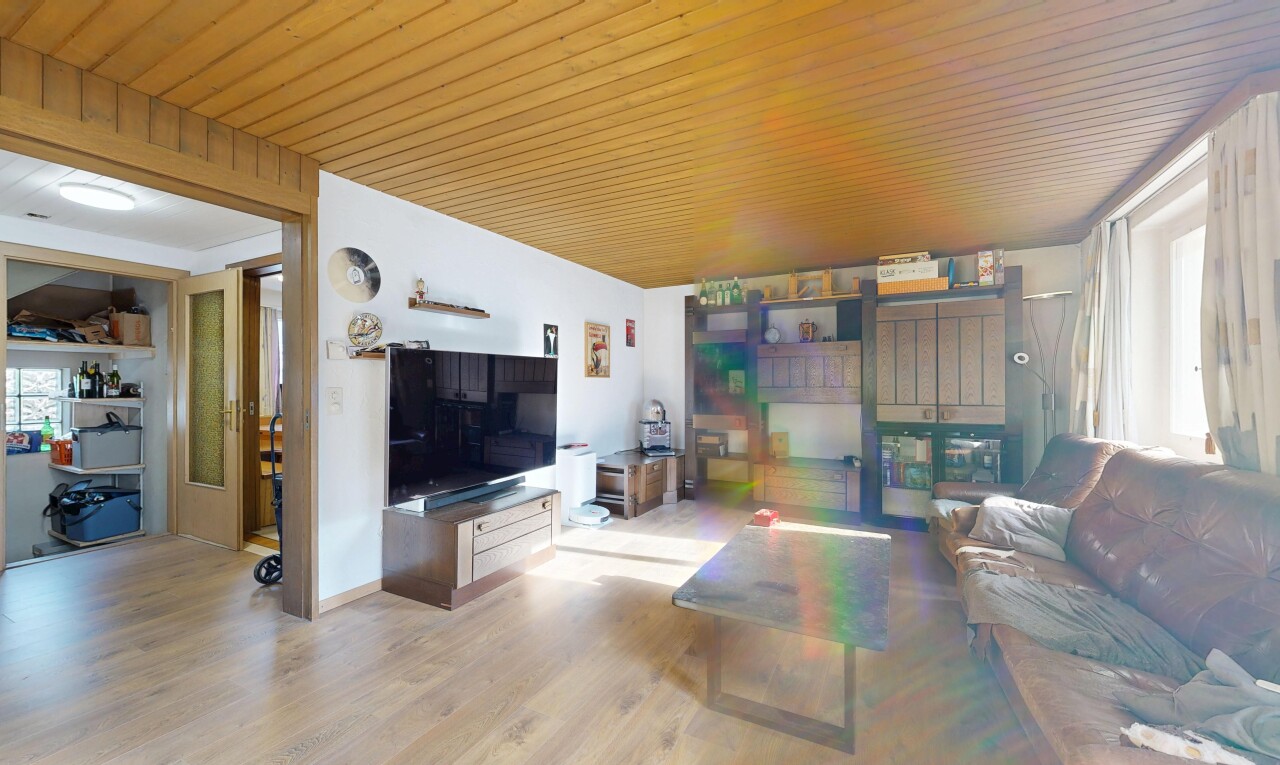 salon avec télévision, inside property, wood finish floor, sol en finition bois, et drywall