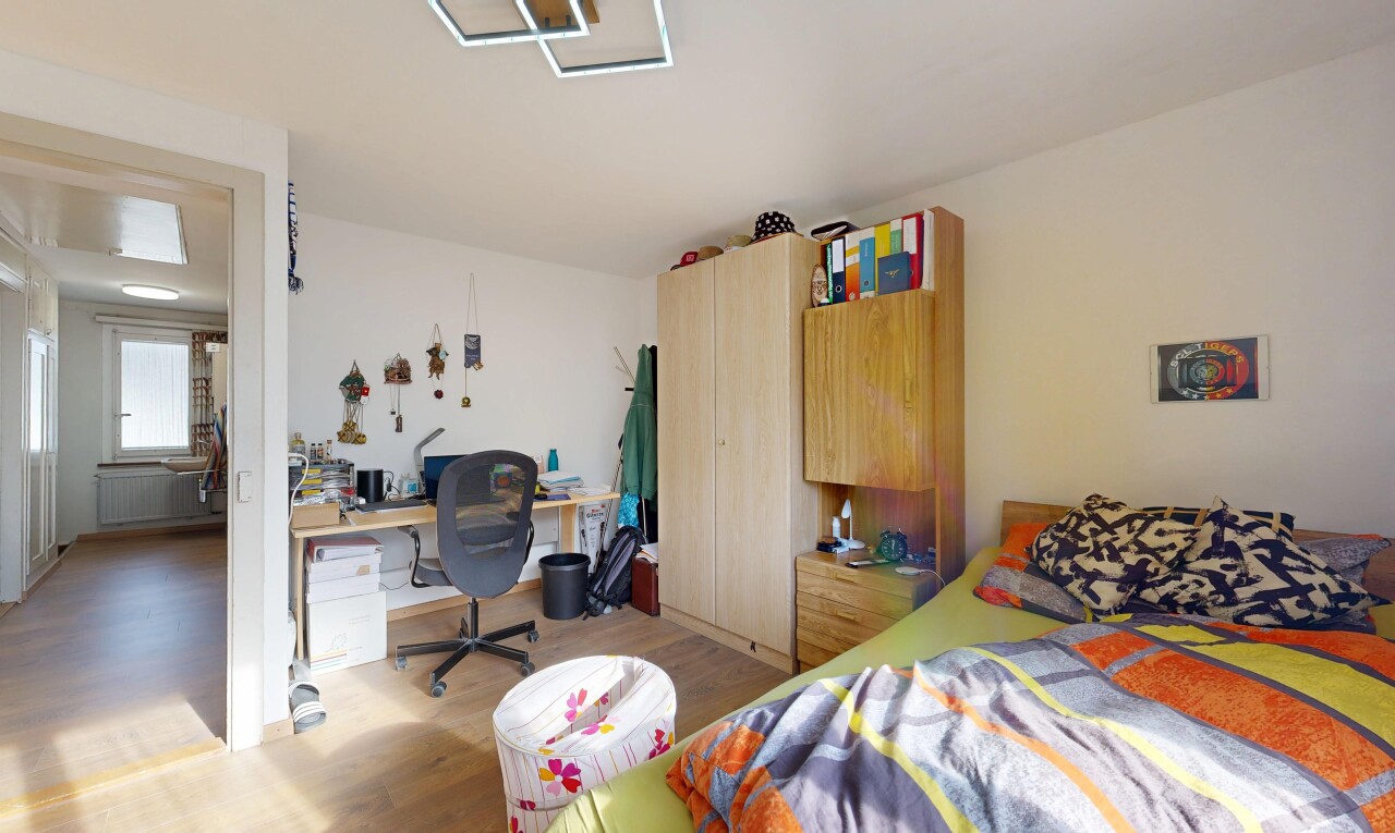 chambre avec espace bureau, inside property, wood finish floor, sol en finition bois, et drywall