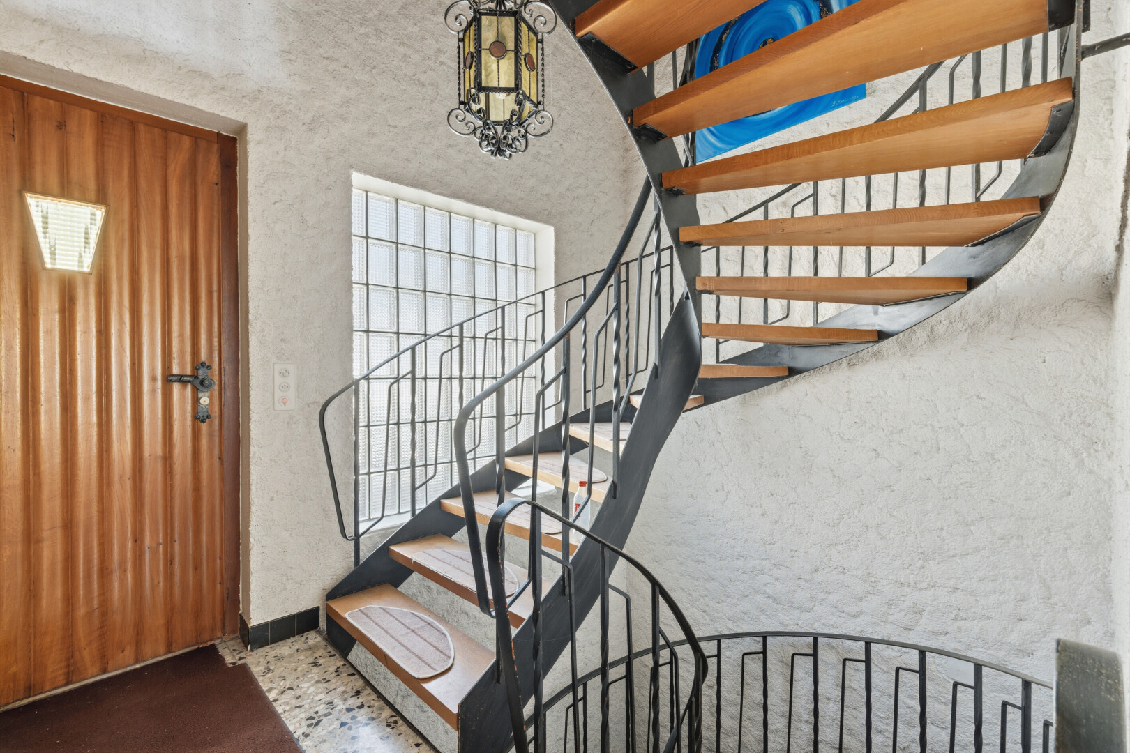 treppe mit treppen, bemerkenswerter kronleuchter, strukturierte wand, und textured wall