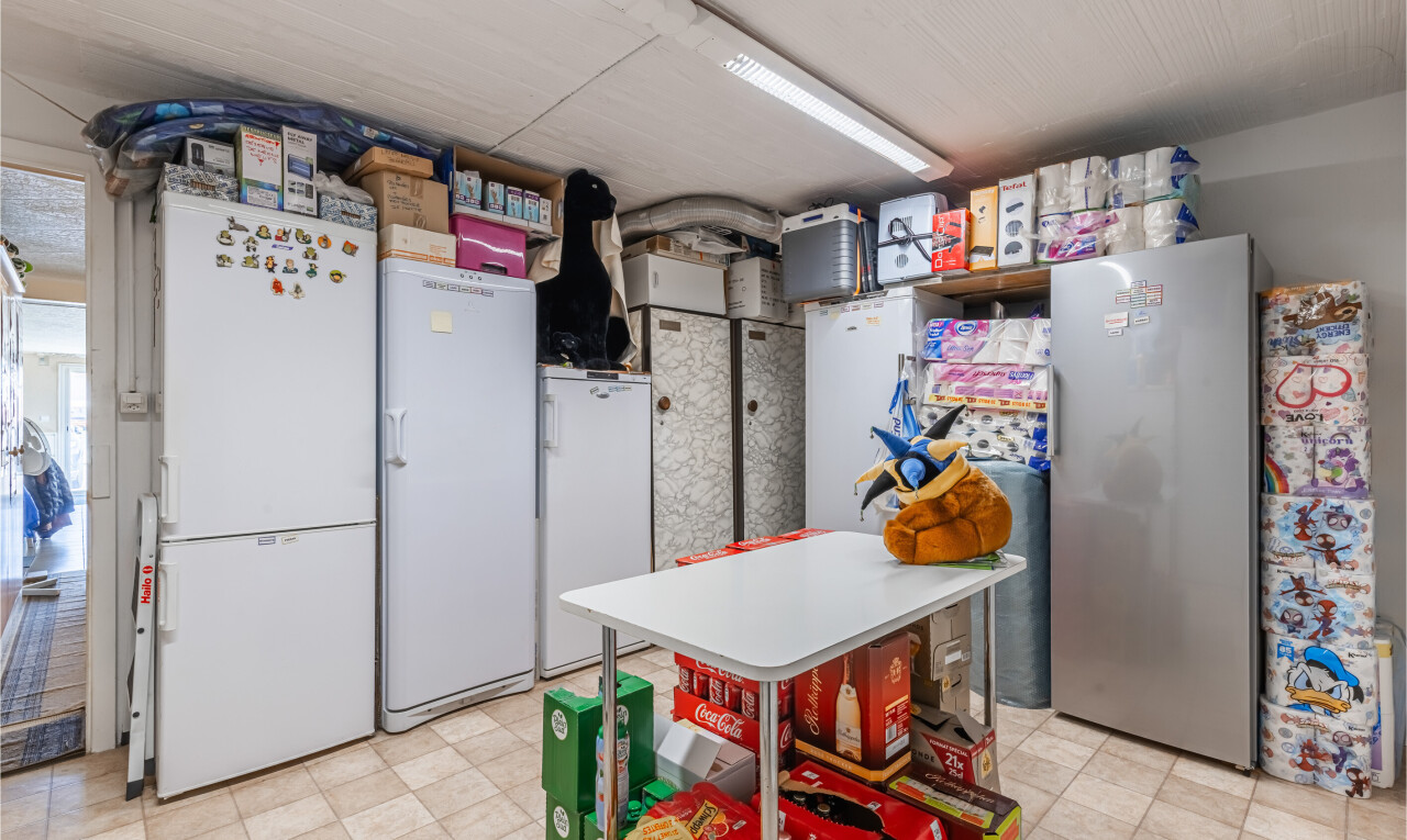 cuisine avec light floor, réfrigérateur, inside property, plans de travail, et light countertops