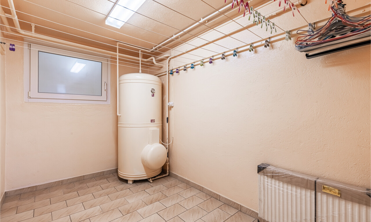 pièce vide avec light floor, inside community, sous-sol, radiateur, et plinthes murales
