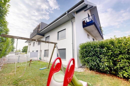 façade avec clôture, property visible, bardage en stuc, pelouse, et balcon