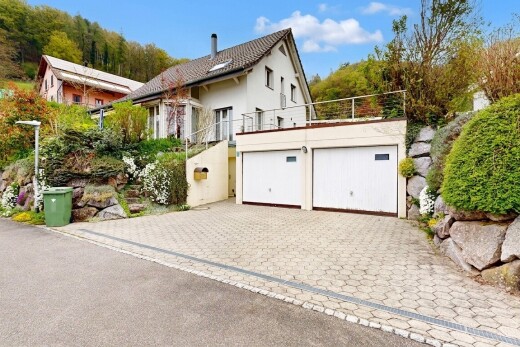 außenansicht mit garage, auffahrt, stuckverkleidung, day time, und property visible