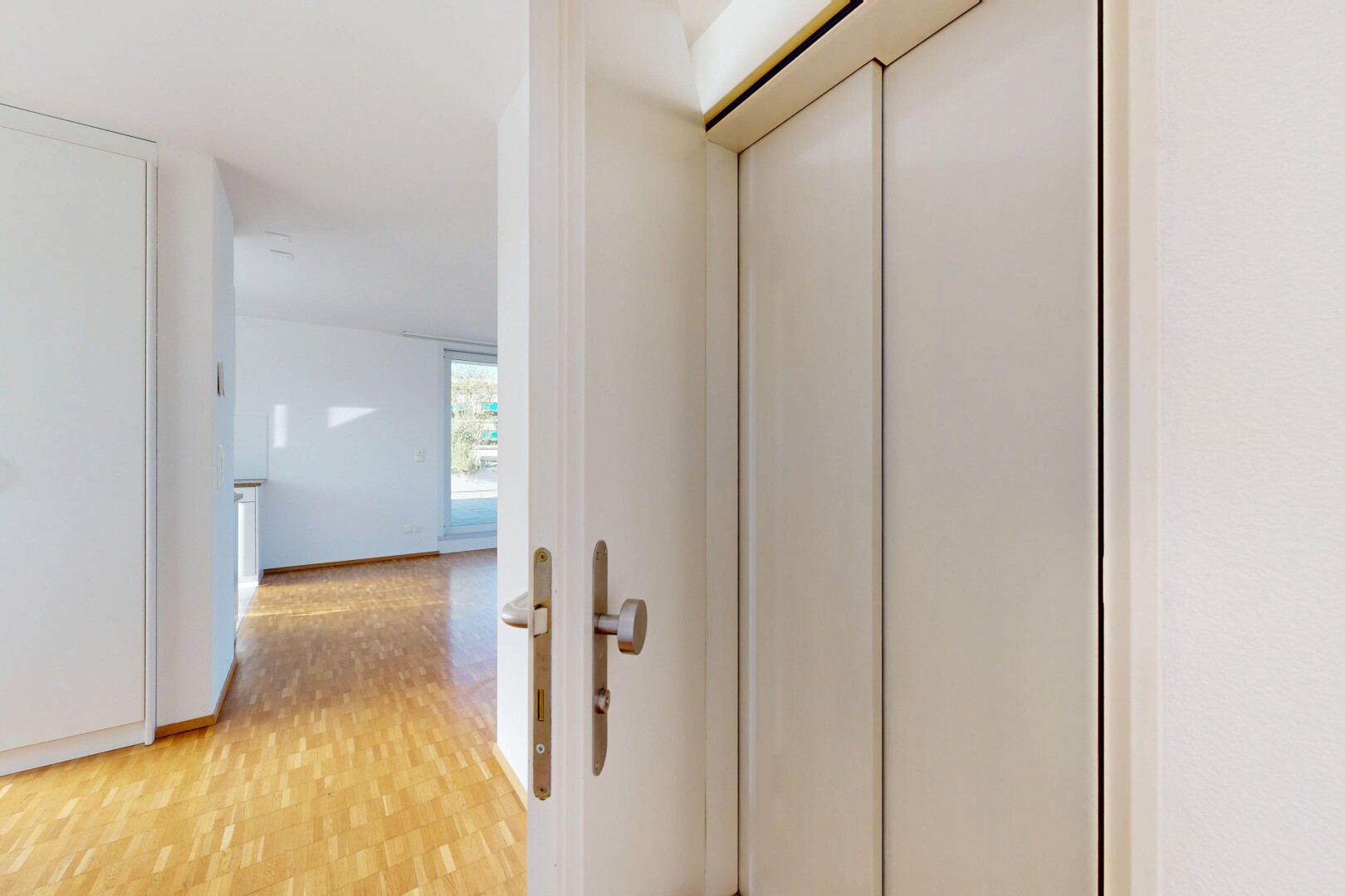 couloir avec sol en finition bois, wood finish floor, inside property, cloison sèche, et drywall