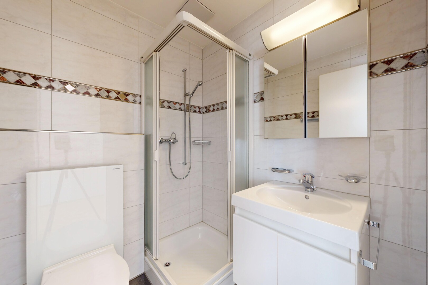 salle de bains avec mur en carrelage, tile wall, miroir, lavabo (ou coiffeuse selon le contexte), et douche