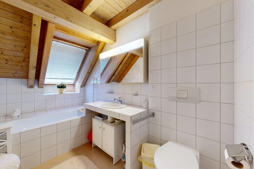 salle de bains avec bain, miroir, lavabo (ou coiffeuse selon le contexte), mur en carrelage, et tile wall
