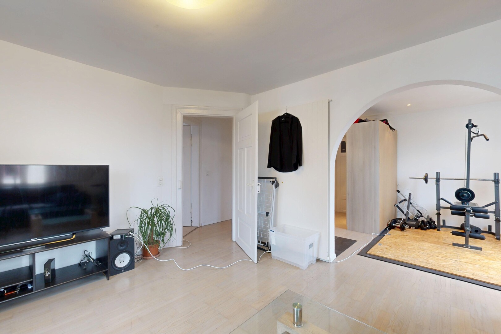 salon avec télévision, cloison sèche, drywall, inside property, et sol en finition bois
