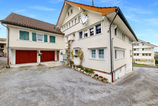 außenansicht mit property visible, auffahrt, day time, ziegelverkleidung, und eingebaute garage