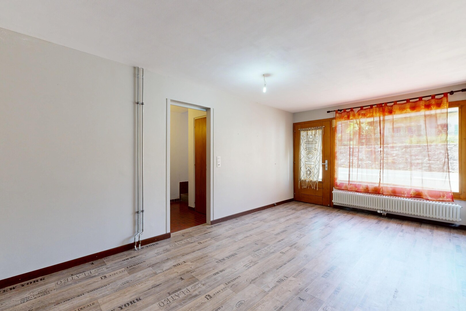 pièce vide avec drywall, cloison sèche, radiateur, wood finish floor, et sol en finition bois