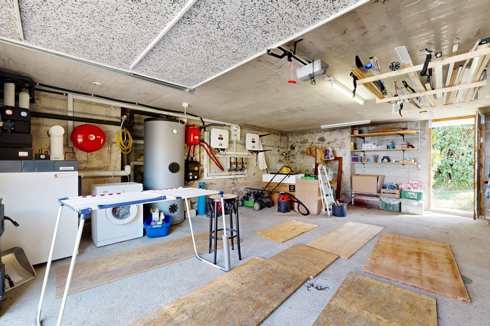cuisine avec lave-linge et sèche-linge, inside property, sol en béton, concrete floor, et chauffe-eau