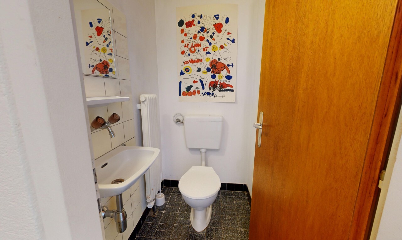 salle de bains avec toilette, dark floor, inside property, drywall, et cloison sèche