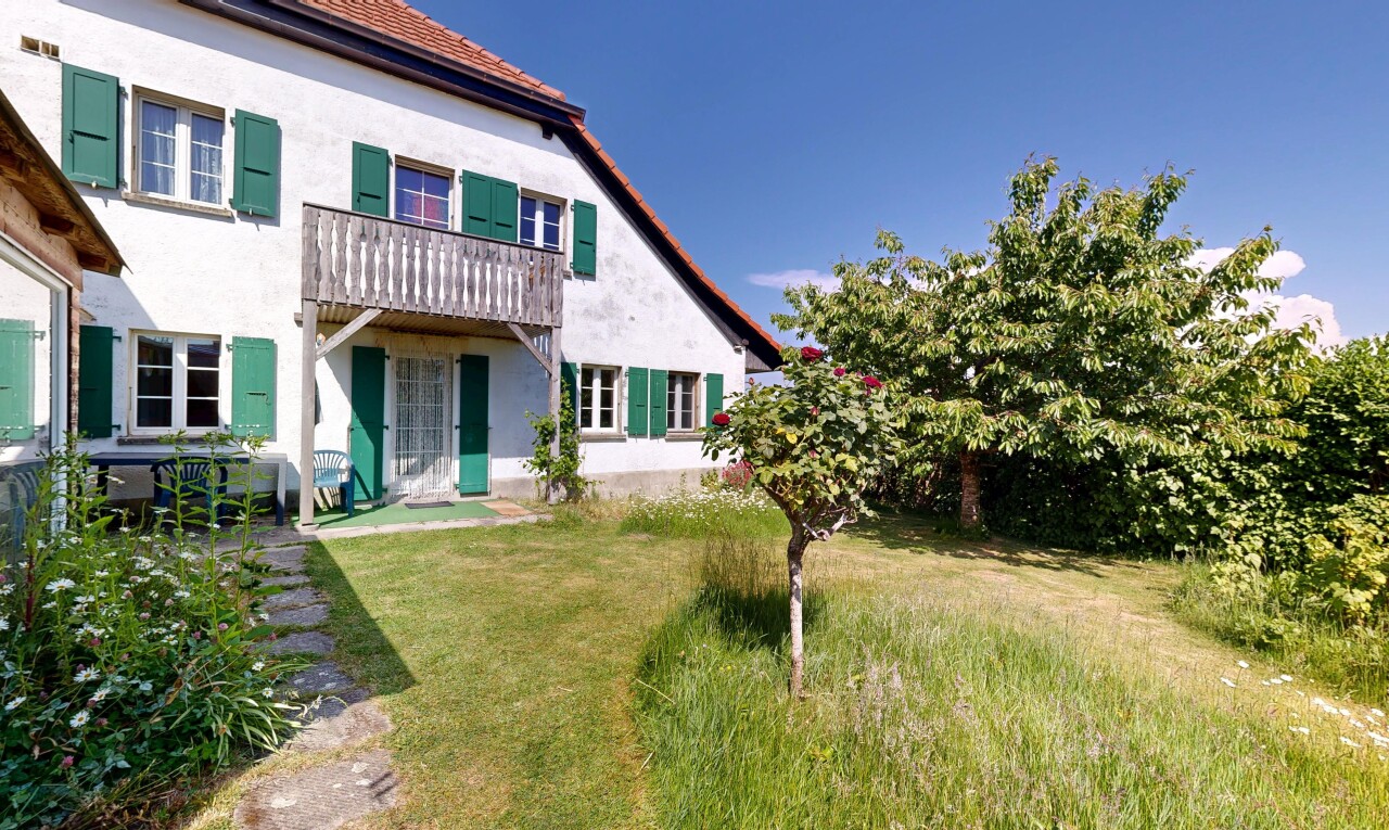 façade avec property visible, bardage en stuc, pelouse, et day time