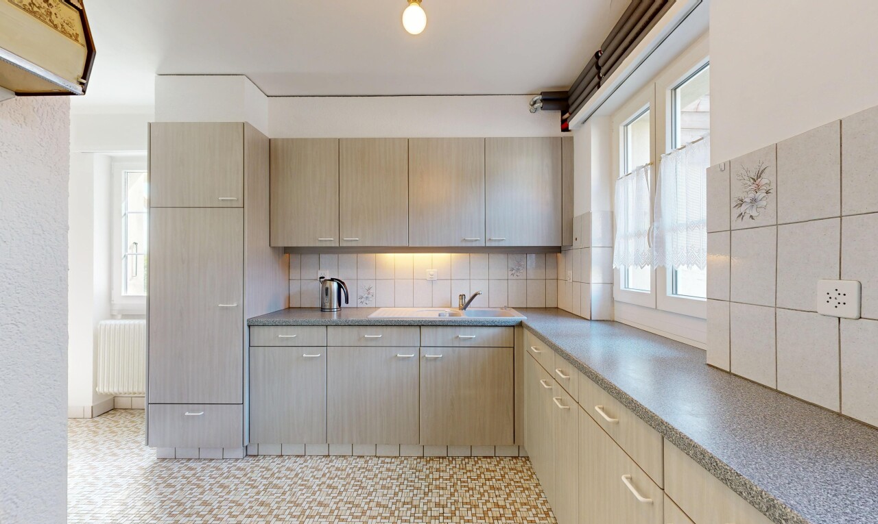cuisine avec dosseret, backsplash, radiateur, light floor, et lumière naturelle