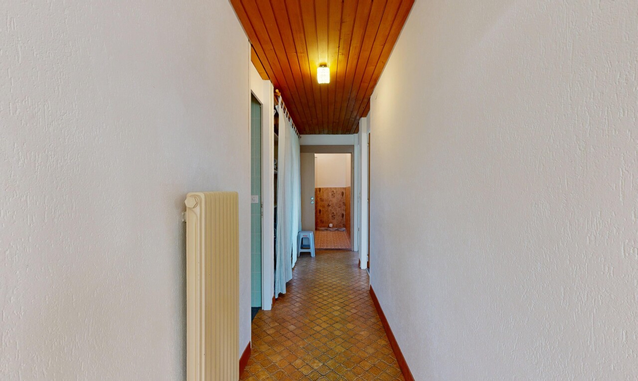 couloir avec wood ceiling, plafond en bois, radiateur, inside community, et baseboards wall