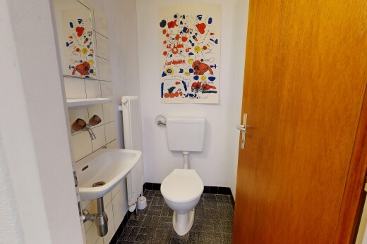 salle de bains avec toilette, dark floor, inside property, drywall, et cloison sèche