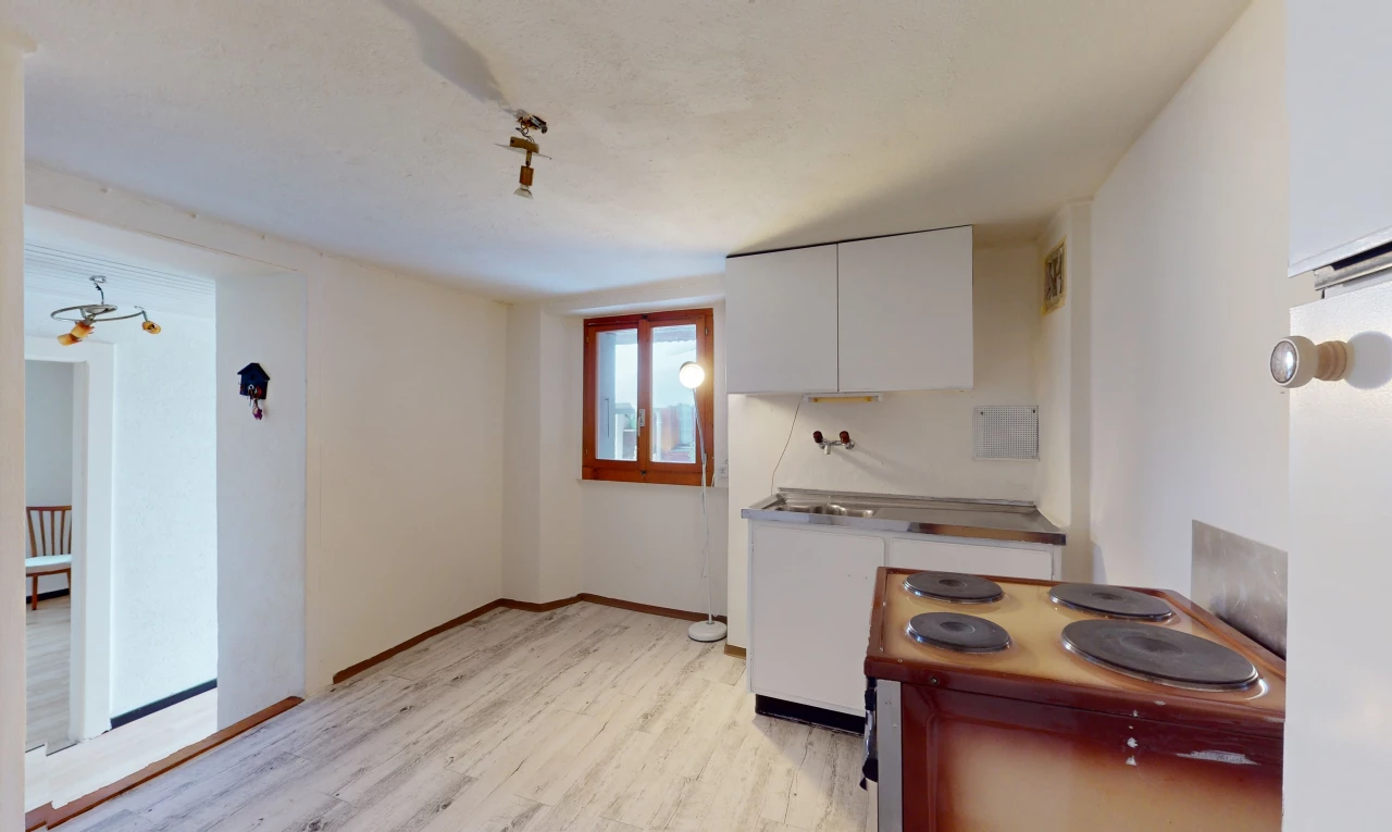 cuisine avec lumière naturelle, plancher de bois, plan de travail, et meubles blancs