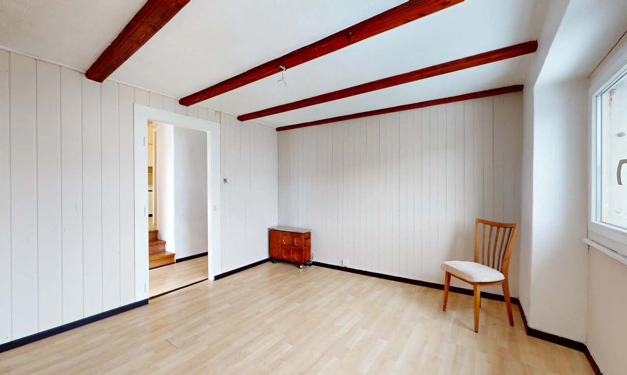pièce vide avec plancher de bois et poutres apparentes