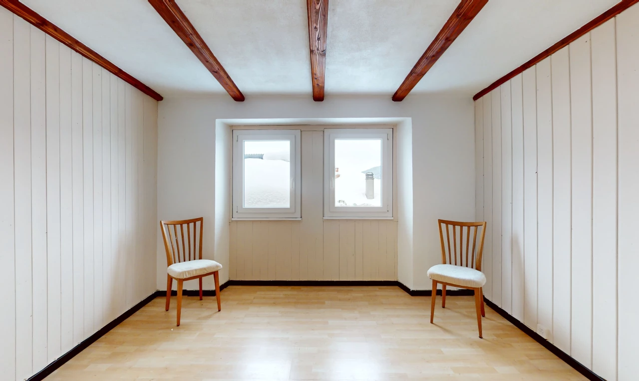 pièce vide avec lumière naturelle, plancher de bois, et poutres apparentes