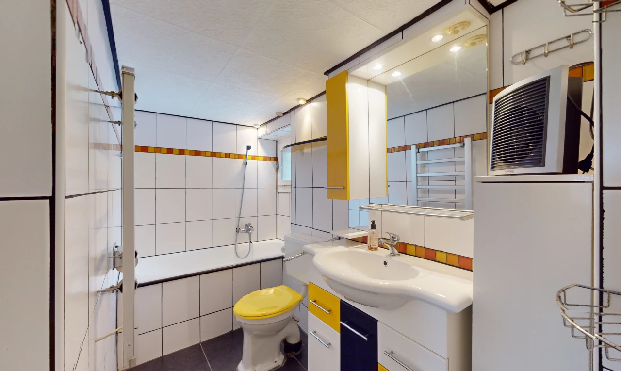 salle de bain avec miroir, meuble-lavabo, vasque, mur carrelé, et toilettes