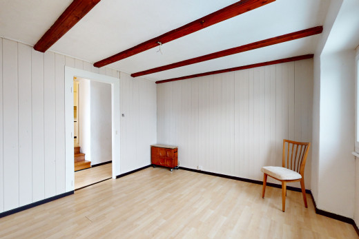 pièce vide avec plancher de bois et poutres apparentes