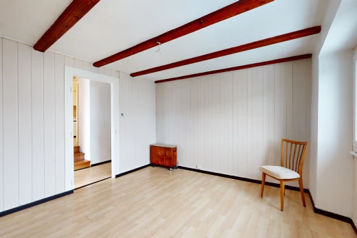 pièce vide avec plancher de bois et poutres apparentes