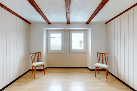 pièce vide avec lumière naturelle, plancher de bois, et poutres apparentes