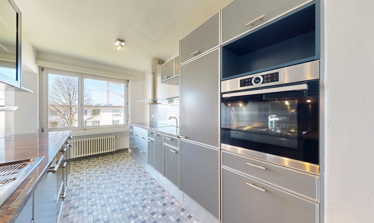 cuisine avec day time, radiateur, inside property, armoires grises, et gray cabinets
