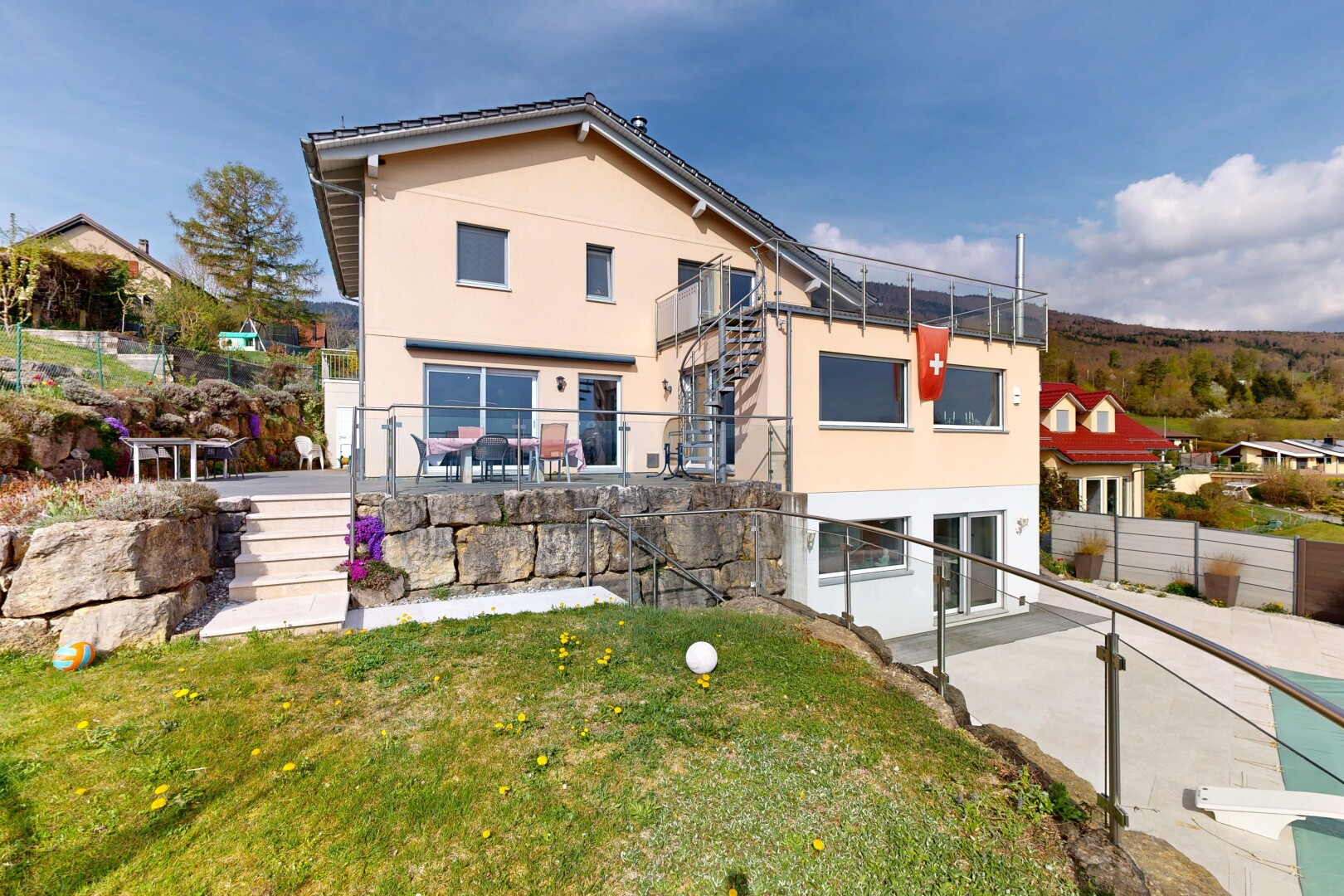 façade avec terrasse, day time, property visible, bardage en stuc, et pelouse