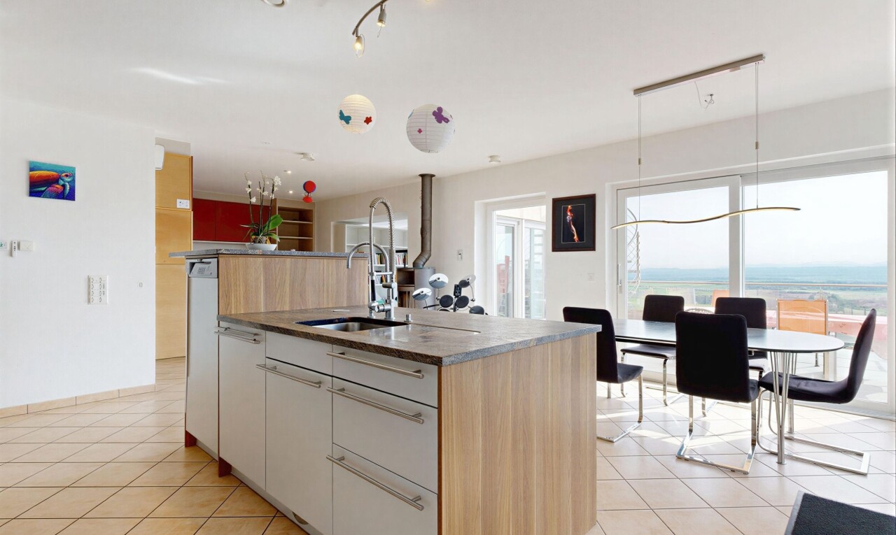 cuisine avec kitchen island, îlot de cuisine, kitchen island sink, light floor, et natural light