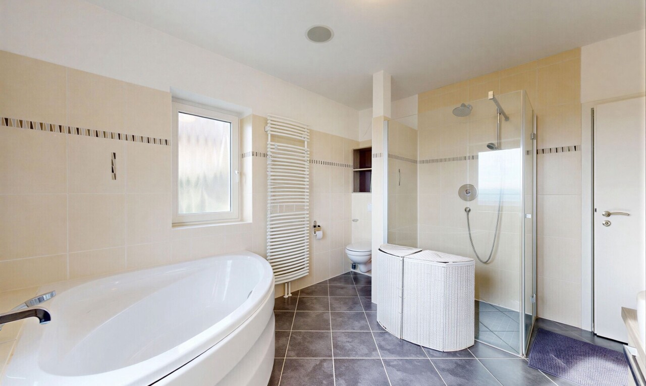 salle de bains avec salle de bain complète, chauffe-serviettes, radiateur, douche, et toilette