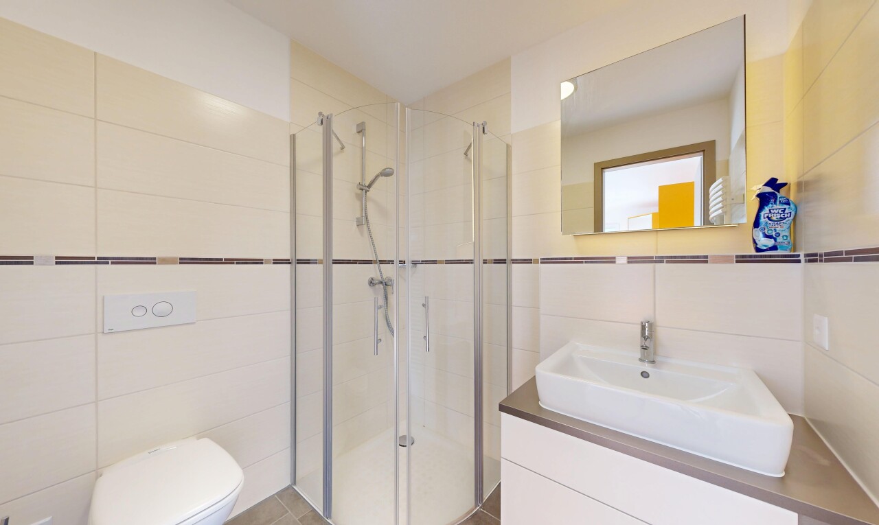 salle de bains avec tile wall, mur en carrelage, lavabo (ou coiffeuse selon le contexte), douche, et salle de bain complète