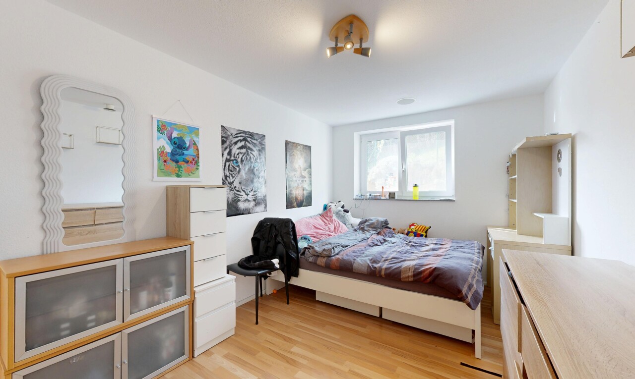 chambre avec wood finish floor, sol en finition bois, light floor, drywall, et cloison sèche