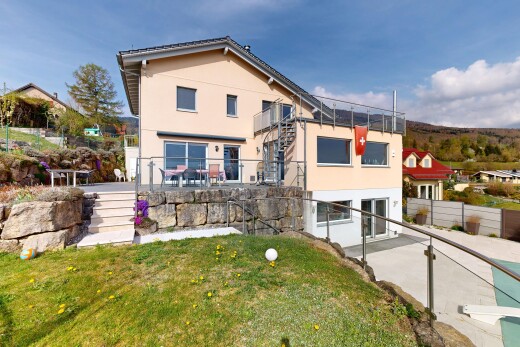 façade avec terrasse, day time, property visible, bardage en stuc, et pelouse