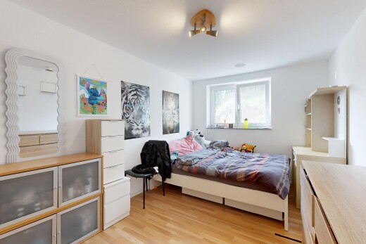 chambre avec wood finish floor, sol en finition bois, light floor, drywall, et cloison sèche