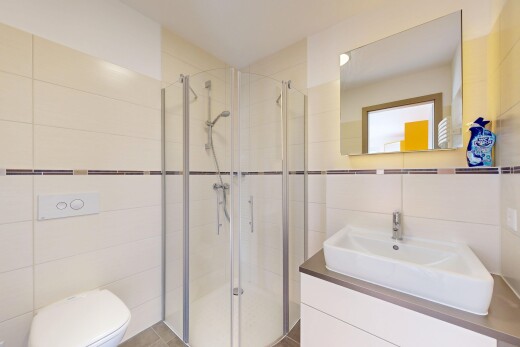 salle de bains avec tile wall, mur en carrelage, lavabo (ou coiffeuse selon le contexte), douche, et salle de bain complète
