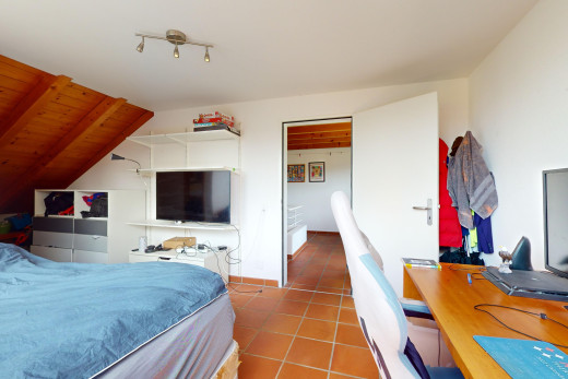 zimmer / schlafzimmer mit fliesenboden, fernsehen, und schienenbeleuchtung