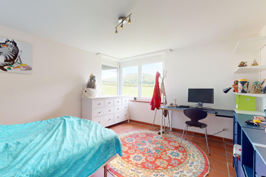 zimmer / schlafzimmer mit fliesenboden, natürliches licht, und fernsehen