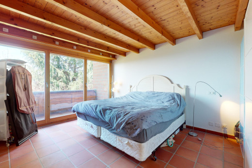 zimmer / schlafzimmer mit holzdecke, natürliches licht, außenzugang, fliesenboden, und balkendecke