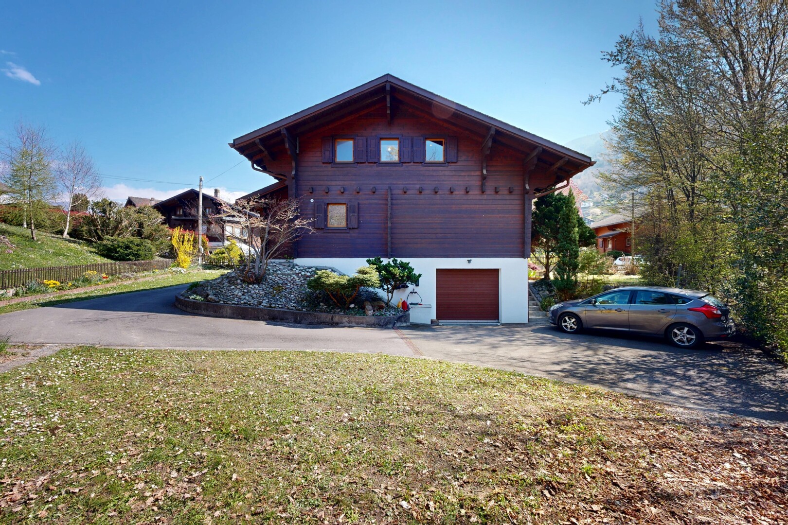 façade avec garage intégré, bardage horizontal, pelouse, garage au sous-sol, et property visible