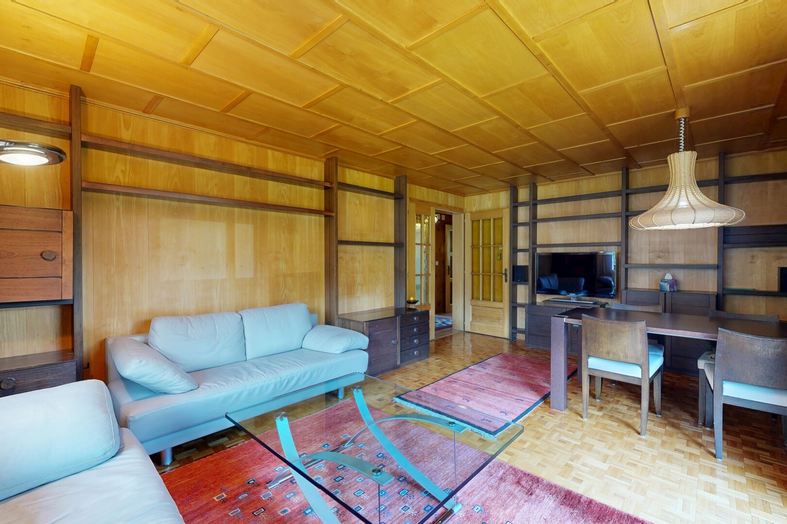 salon / salle à manger avec mur en bois, wood wall, inside property, parquet floor, et télévision