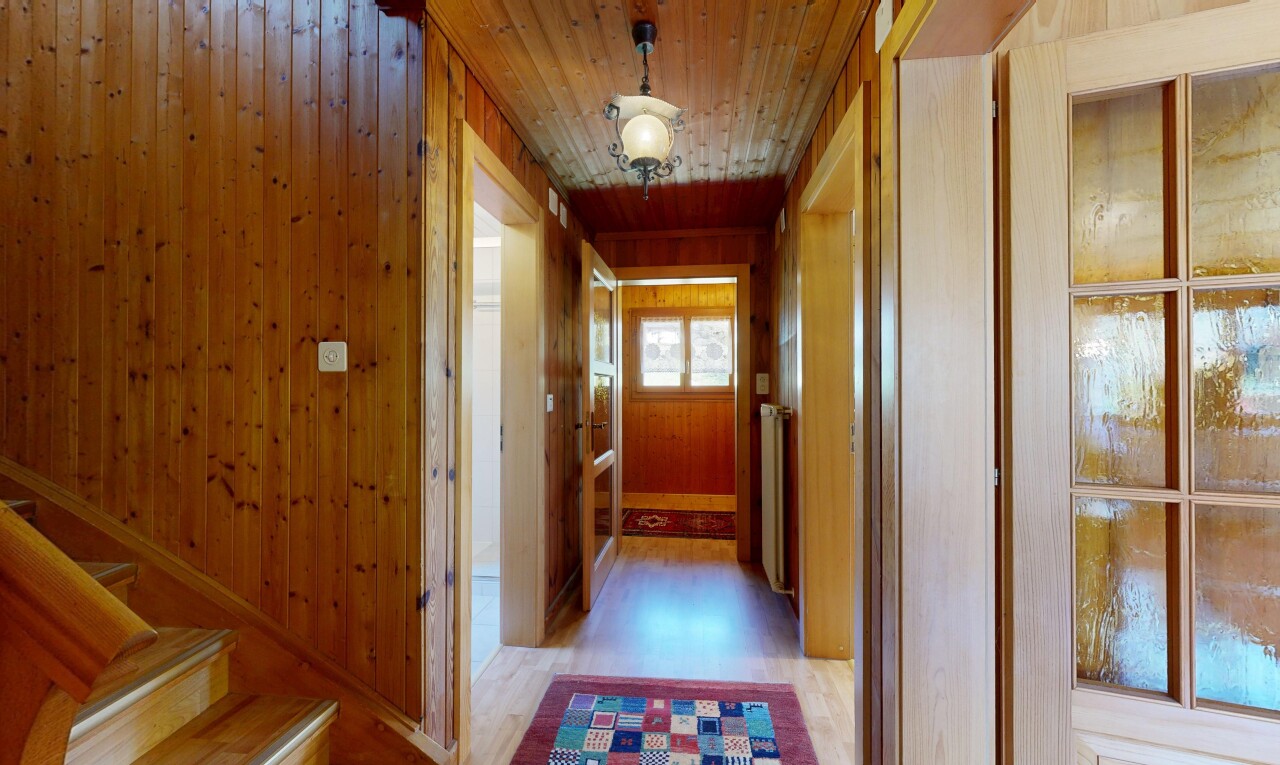 couloir avec wood finish floor, sol en finition bois, wood wall, mur en bois, et inside property
